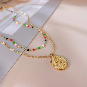 Collier double couche en acier doré avec perles colorées et pendentif relief rose