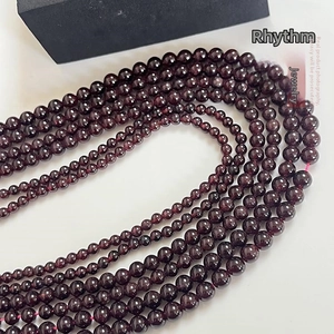 Gros plan de perles de grenat rouge foncé pour bijoux DIY avec une finition polie
