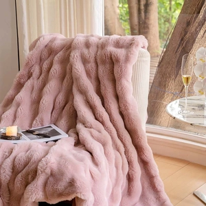 Luxurious soft pink faux fur throw blanket draped over a sofa for cozy home decor