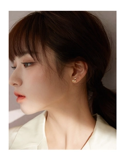 Close-up of cherry stud earrings with gold finish and small crystals on female model