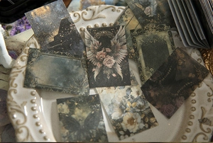 Detail of vintage decorative paper featuring angel wings and butterfly motifs on a white plate