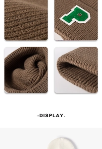 Close-up of brown knit beanie showing green letter P embroidery and ribbed texture