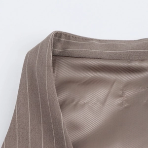Detailed close-up of brown pinstripe trousers showing the premium satin waist lining