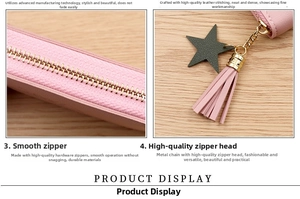 Detail of pink leather coin purse featuring gold zipper with star charm and tassel