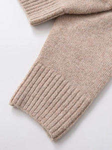 Detail of oatmeal ribbed knit texture on the sleeve and hem of the minimalist sweater