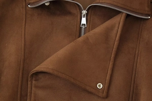 Detail van een premium bruin suède jas met een hoogwaardige zilveren metalen rits