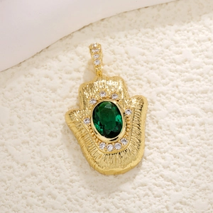 Macro detail of Hamsa Hand pendant with green gemstone and hammered gold finish