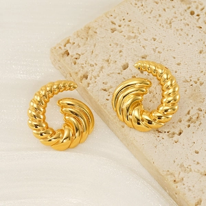 Polished 18k gold spiral twisted stud earrings on elegant textured stone pedestal