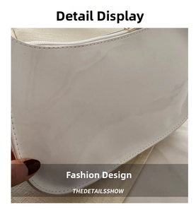 Detailed close-up of glossy white patent leather finish and fine stitching on baguette bag