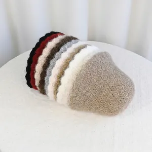 Winter plush bucket hats in assorted solid colors stacked on a textured surface