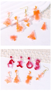 Flat lay of gradient resin Christmas earrings including trees, snowflakes and gingerbread men