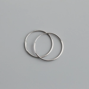 Macro shot of polished S925 sterling silver hoop earrings with classic clasp detail