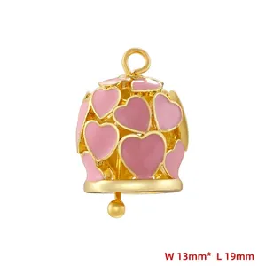 Detailed macro of gold bell pendant with pink enamel hearts, 13mm by 19mm size