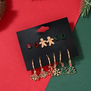 Christmas earring set with snowflakes, trees, and gingerbread man motifs on a festive card