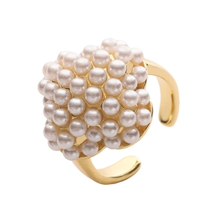 Detailed view of gold cluster ring with white pearls and adjustable open band design