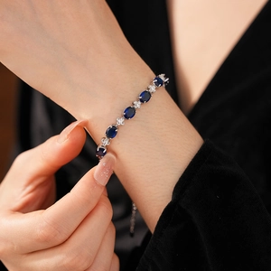 Detailed close-up of a silver zircon bracelet with deep blue oval gemstones on wrist