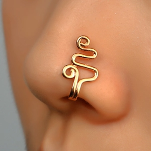 Close-up of a golden spiral non-piercing nose clip worn on a model nose for detail