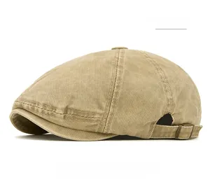 Close-up of khaki denim beret featuring adjustable side strap and metal buckle detail