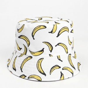Close-up of a white bucket hat with vibrant yellow banana print and high-quality canvas texture