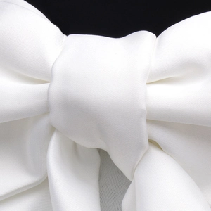 Macro view of a white satin bridal bow accessory with smooth silk texture details