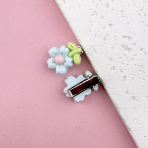 Detailed view of light blue resin flower hair clips with pink centers and metal clips