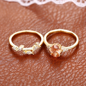 Macro shot of gold leaf petal ring set with champagne stone on brown leather