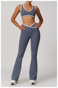 Detail of high-waisted flared yoga pants and v-neck top with contrast white piping