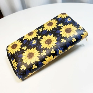 Macro detail of vibrant sunflower floral prints on a long PU leather zipper wallet