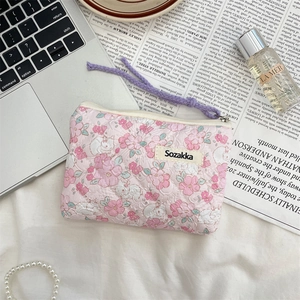 Detailed close-up of a pink floral quilted cosmetic bag with a cute rabbit pattern