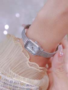 Close-up of a silver square quartz watch with rhinestone bezel and metal mesh band
