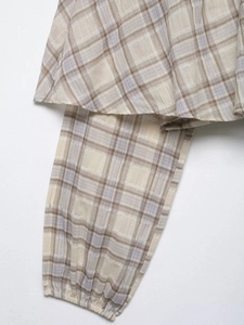 Detail of vintage plaid long sleeve top with elastic cuffs and woven cotton fabric texture