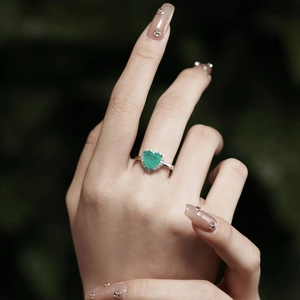 Close-up of a sterling silver ring with a heart-shaped emerald green zircon stone