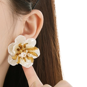 Vintage style 18K gold hollow petal earrings with pearls on model for beach vacations