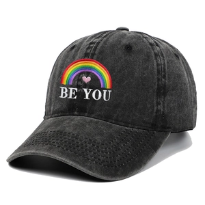 Close-up of rainbow embroidery and 'BE YOU' text on washed cotton denim baseball cap