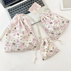 Detailed set of three drawstring pouches in small, medium and large size on a desk