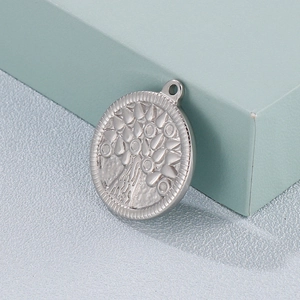 Polished silver stainless steel Tree of Life pendant displayed on a geometric prop