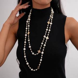 Vue détaillée du collier de perles superposé avec pendentifs croix dorés et zircons