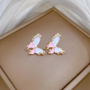 Detail of butterfly earrings with pink enamel, gold plating and small rhinestones