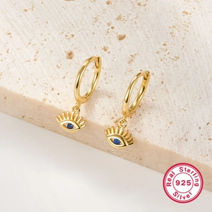 Detailed macro view of S925 sterling silver evil eye earrings with blue zircon in gold finish