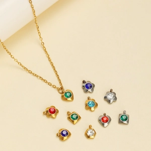 Colorful zircon charms in heart and floral shapes on a gold necklace display