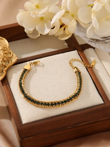 Detail of bohemian gold snake chain bracelet with dark green crystals and lobster clasp