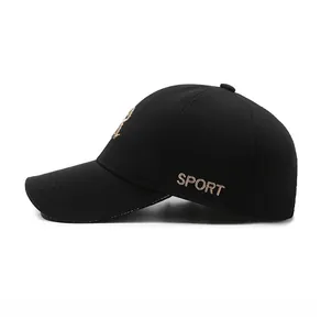 Detail of black baseball cap featuring golden side embroidery and classic curved brim