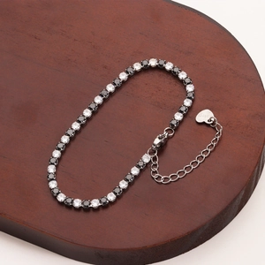 Detail view of silver stainless steel tennis bracelet with clear and black cubic zirconia stones