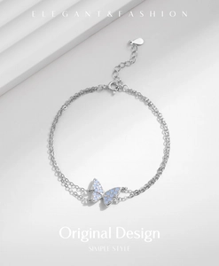 Macro shot of silver double-layered butterfly bracelet with blue stone inlay and chain