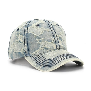 Détails d'une casquette en denim bleu délavé avec déchirures vintage et bords effilochés