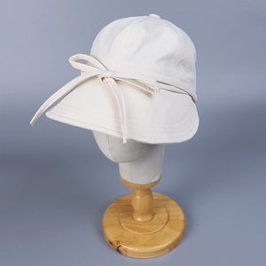 Detailed view of beige sun hat featuring a delicate bow tie and premium stitching