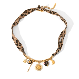 Detail of leopard print fabric strap gold necklace with sun, moon, and heart pendants