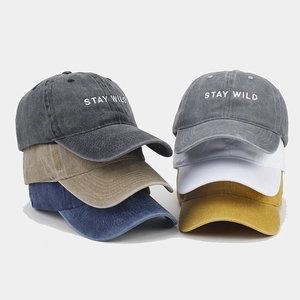Detailed stack of washed cotton baseball caps in multiple vintage colors with embroidery