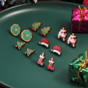 Festive Christmas stud earrings set featuring Santa, reindeer, and tree on green tray