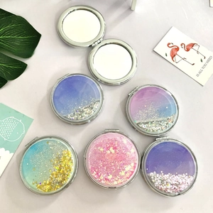Detail of round folding mirror featuring colorful liquid quicksand and glitter on the cover